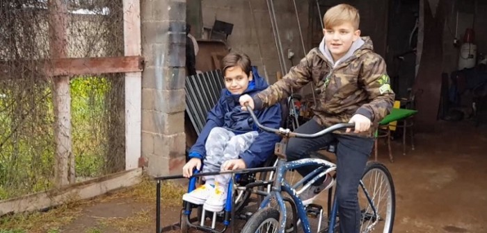 La genial idea de niño para cumplir sueño de andar en bici con su primo en silla de ruedas