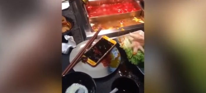 Por no prestar atención a su pareja hombre terminó con su celular sumergido en agua caliente