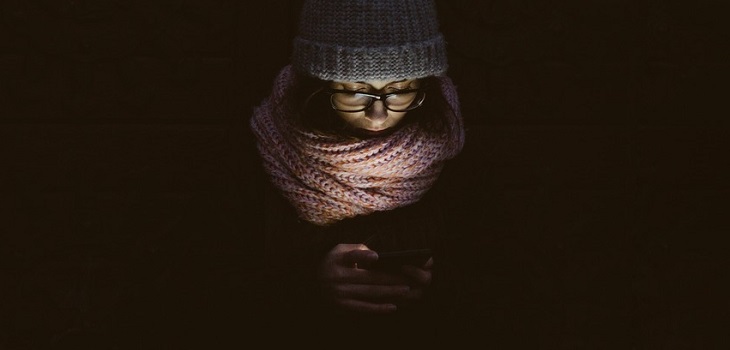 joven con glaucoma por celular en la noche