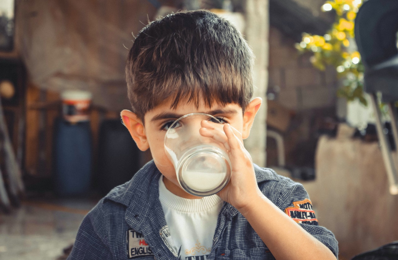 Niño bebiendo leche en vaso