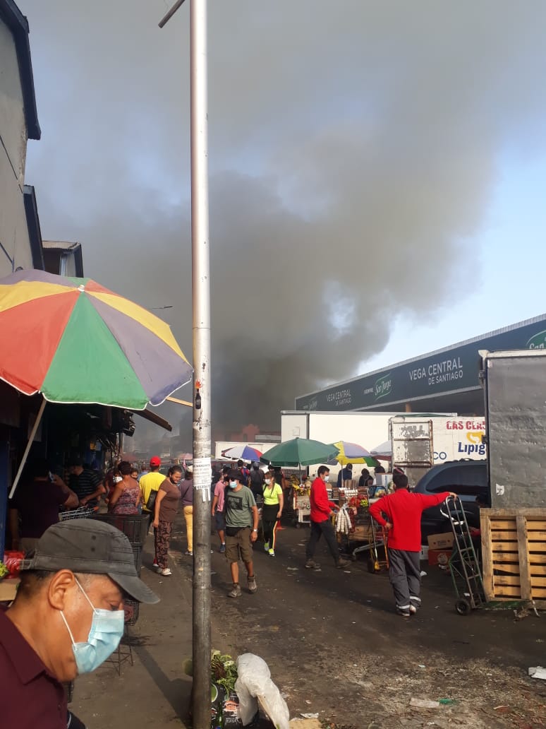 Bomberos trabajan para controlar incendio que afecta a local a un costado de la Vega Central